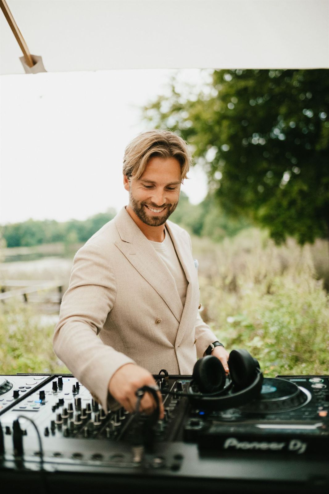 DJ Vejlgaard smiling behind the decks outdoors